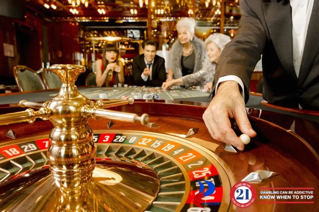 Live roulette game in a casino with a dealer spinning the wheel as players bet at the table.